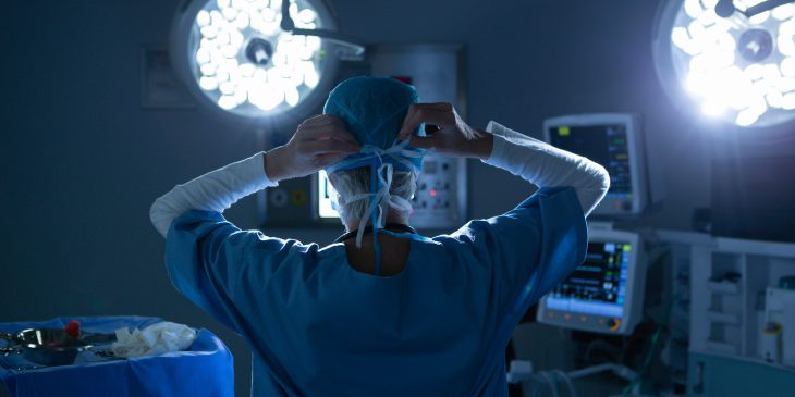 Female surgeon wearing surgical mask in operating room of hospital