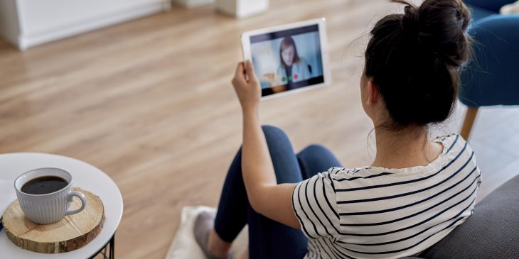 Young woman having a video conference with her doctor