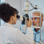 Vision, eye exam and healthcare with a doctor woman or optometrist testing the eyes of a man patient in a clinic. Hospital, medical or consulting with a female eyesight specialist and senior male