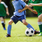 Youth Soccer Match.  Kids Playing Football on Grass Field in Team Uniforms. Children Sports Activity and Competition